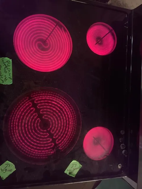 Glass cooktop with radiant elements glowing during a test