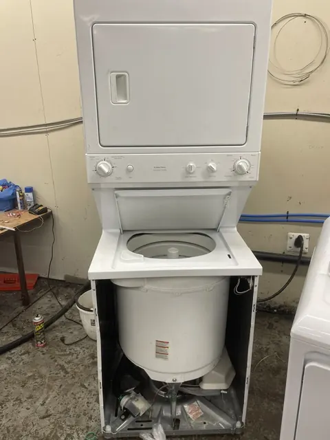 Stacked washer-dryer laundry centre with the lower panel removed